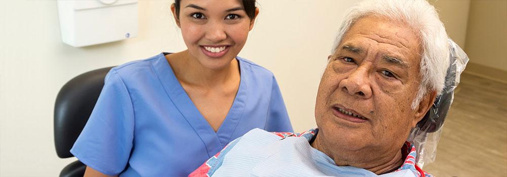 A medical professional is happily with an elderly hawaiian patient