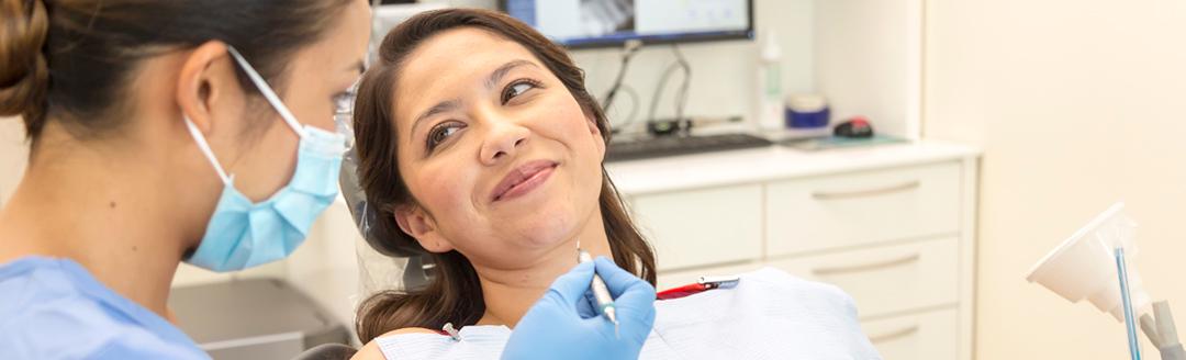 A dentists is performing a procedure on a patient to treat receding gums